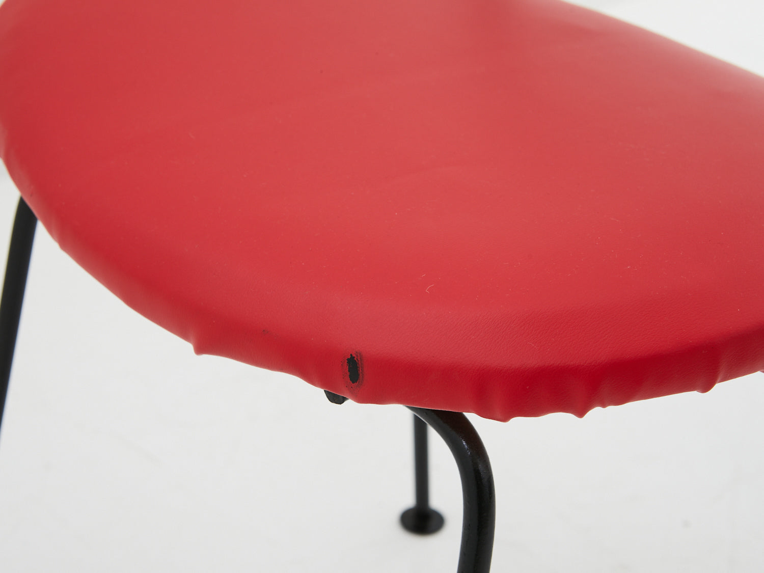 Close up of damage to red seat cushion on Arthur Umanoff dining chair