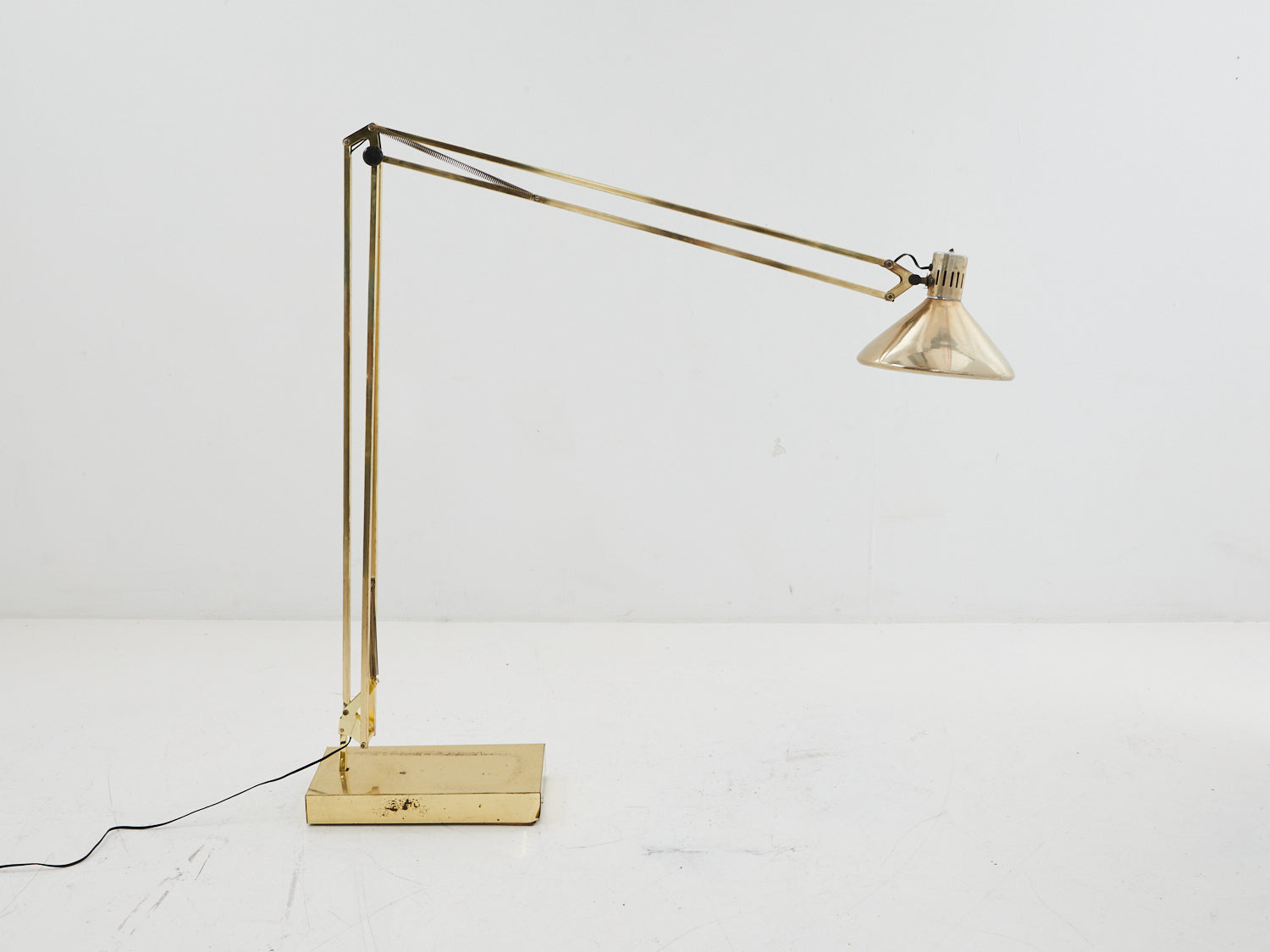 Adjustable brass floor lamp bent at angle