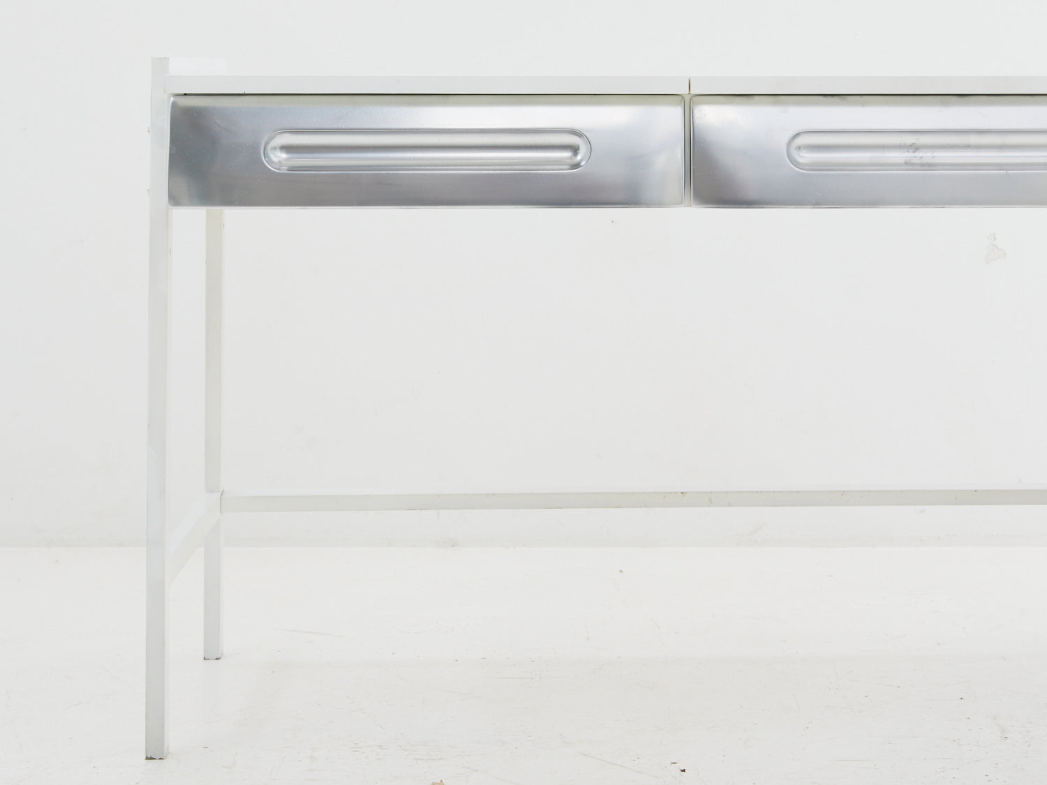Close up of silver faux drawer fronts on a flip-top desk in the style of Raymond Loewy