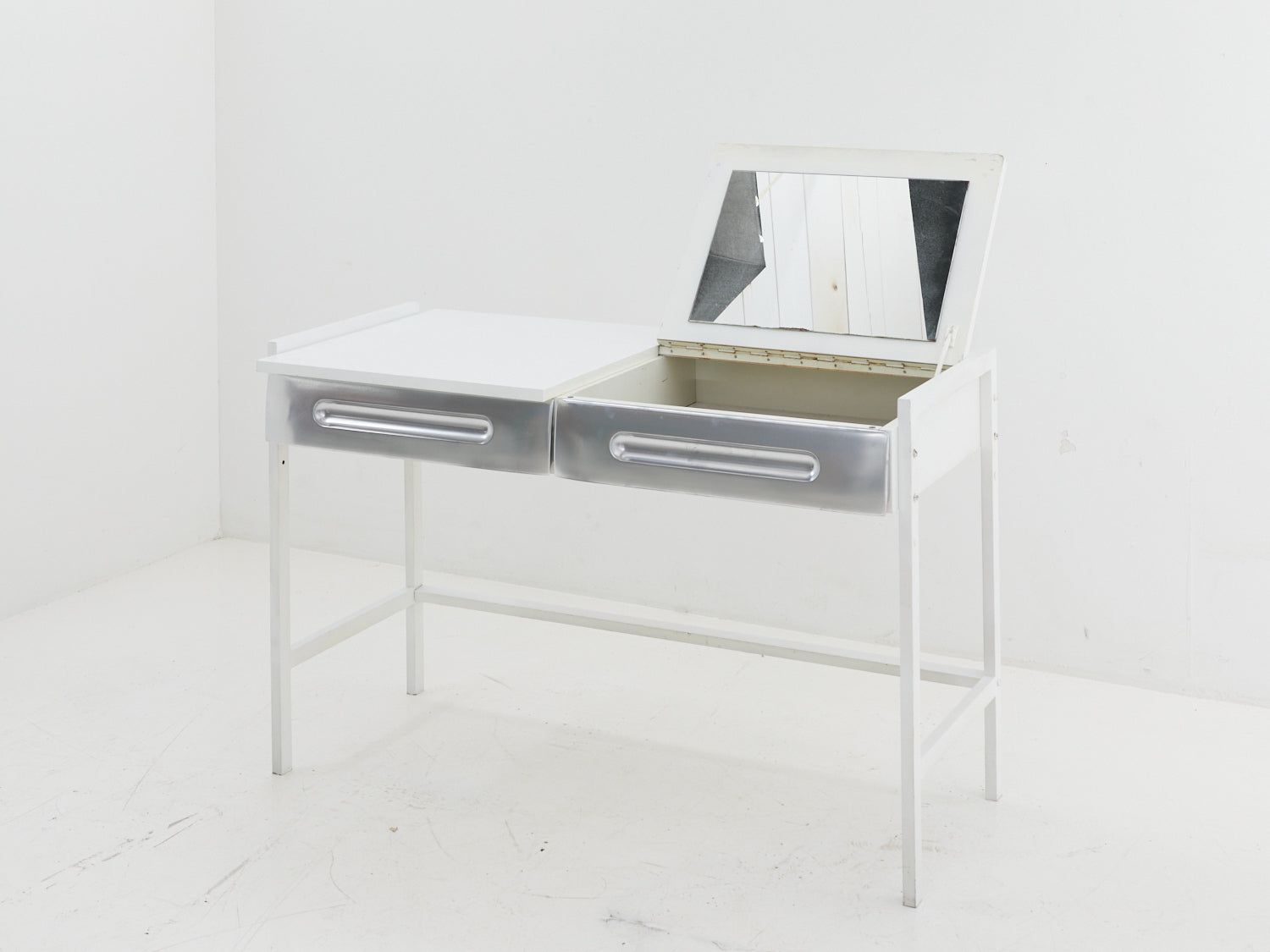 Angled view of the white and silver flip-top desk in the style of Raymond Loewy