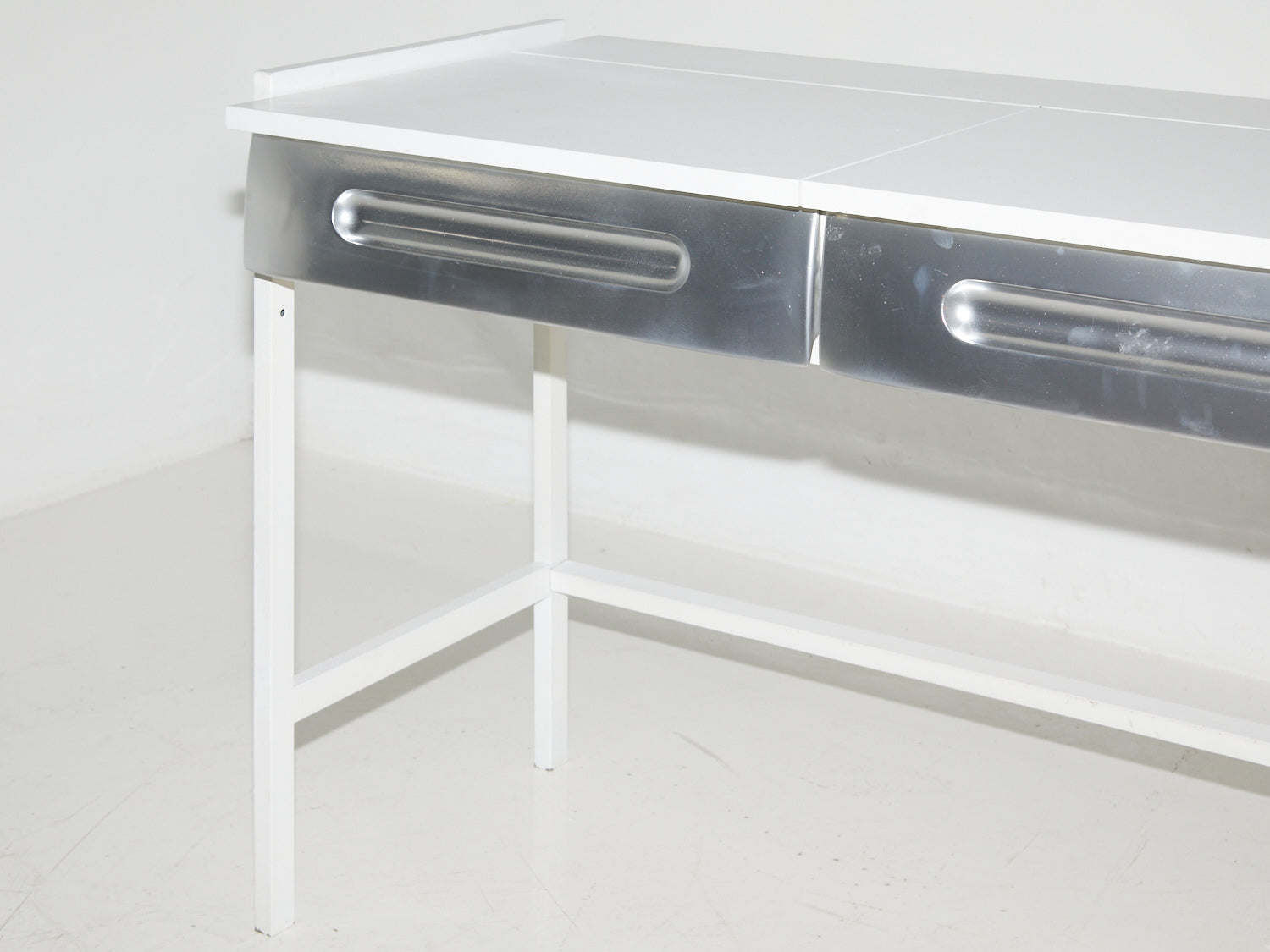 Close up angled shot of silver desk drawers in the style of Raymond Loewy