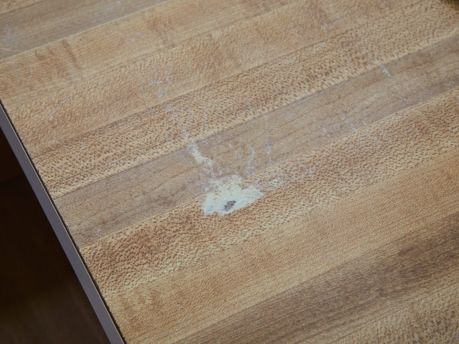 Close up of damage to faux wood formica