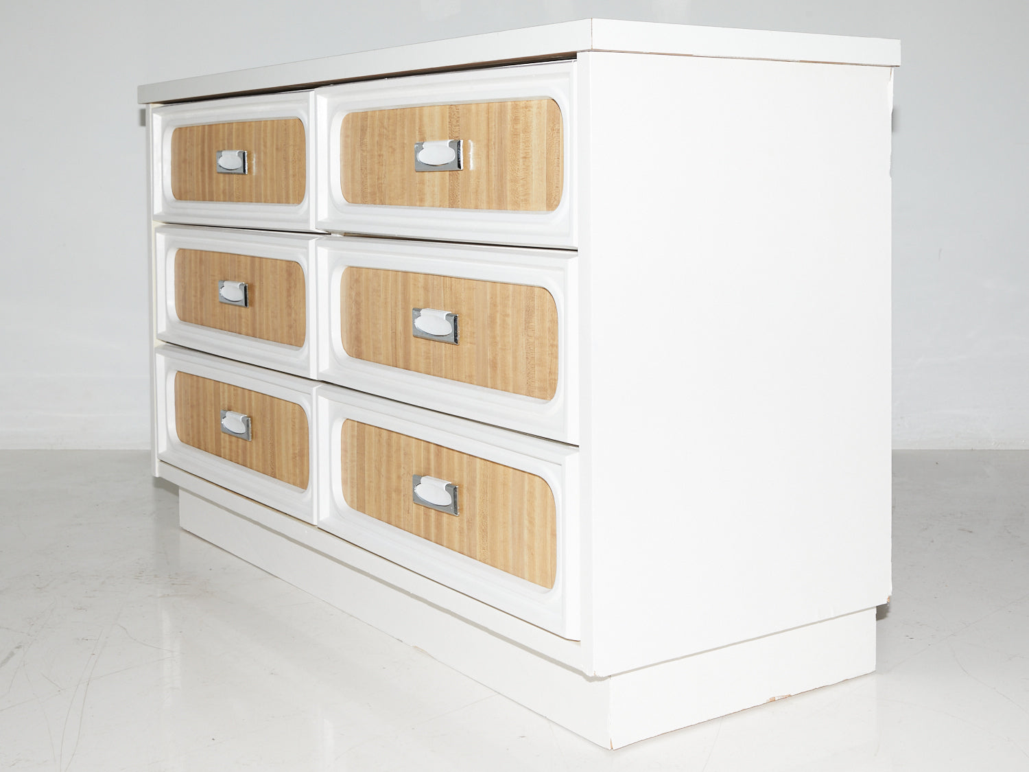 Side view of a faux wood formica dresser with 6 drawers